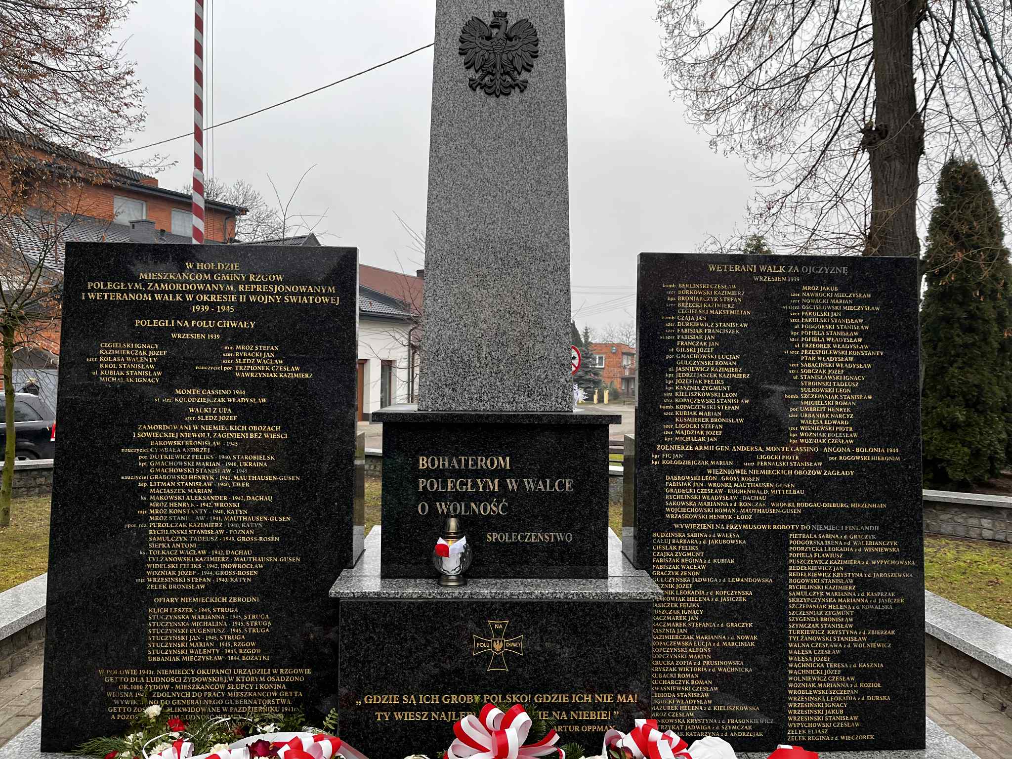 Granitowy tryptyk z centralnym obeliskiem, na którym widnieje godło Polski.