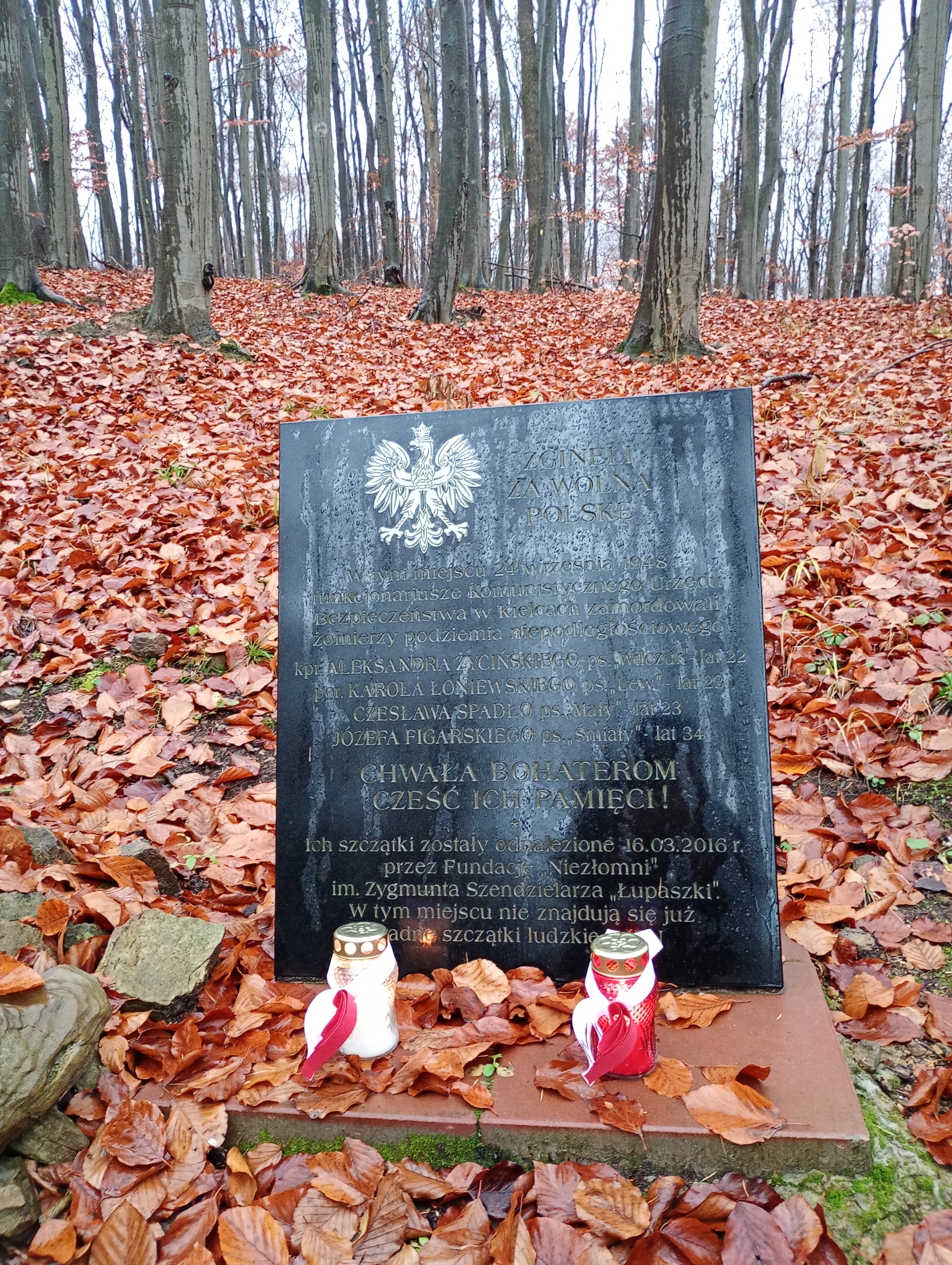 Płyta granitowa z imionami i nazwiskami zamordowanych zołnierzy oraz brzozowy krzyż