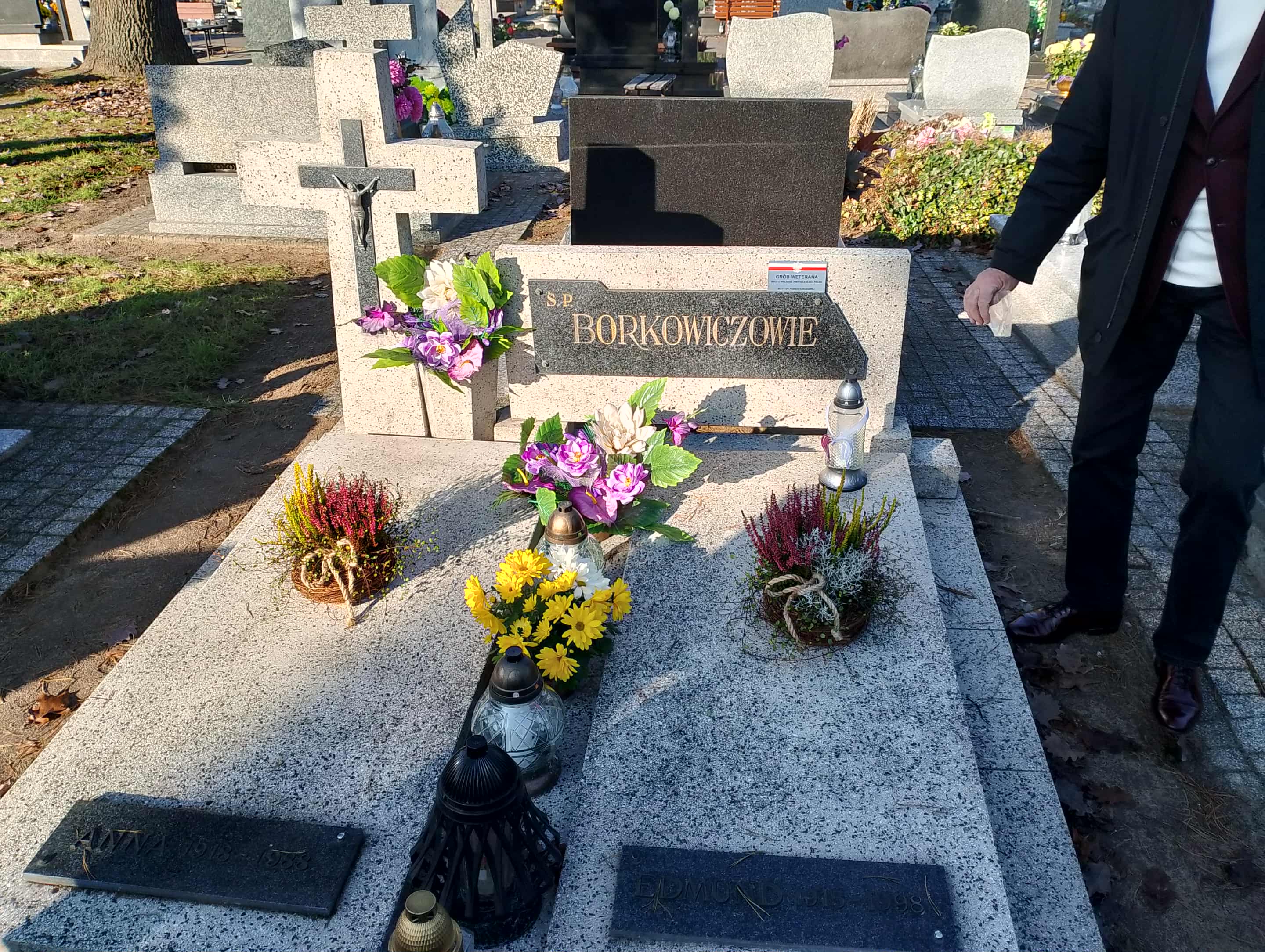 grób rodzinny z napisem "Borkowiczowie", kwiaty, znicze