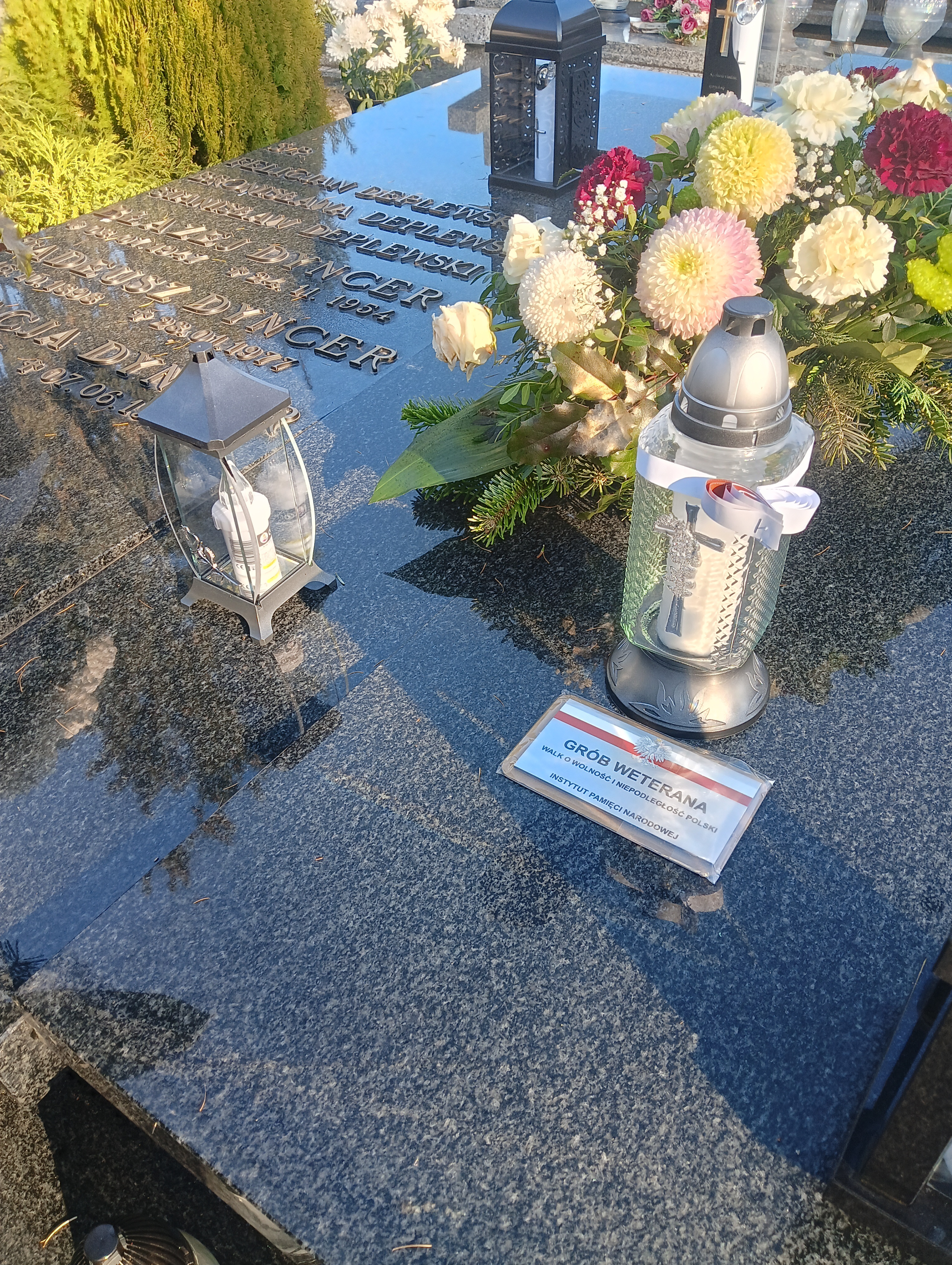 grobowiec rodzinny, na płycie głównej imiona i naziska osób zmarłych, kwiaty, znicze